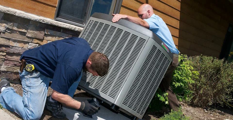 Technicians replacing a residential air conditioner